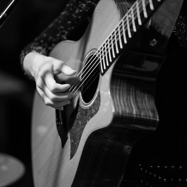 Tamara Hey fingerpicking at a show at Pianos, NYC. The guitar is a Taylor acoustic.