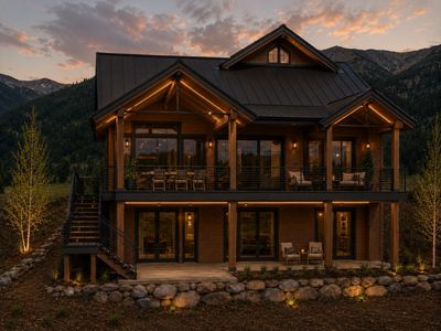 Cozy modern cabin at dusk with warm lights.