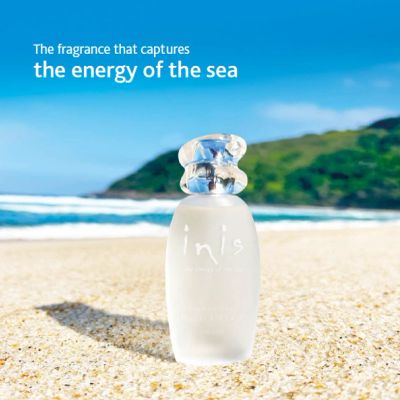 A perfume bottle on a sunny beach with the tagline about sea energy.