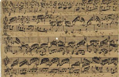 Aged handwritten classical music sheet with intricate notes and markings.