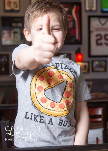 Little boy giving his thumbs up after a  photo session with lifelong photography on location