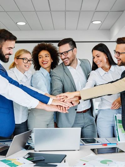 Corporate team members putting their hands in a pile in front of them - as a sign of agreement or bu