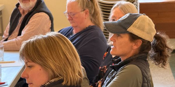 People attentively listening in a meeting or class setting.