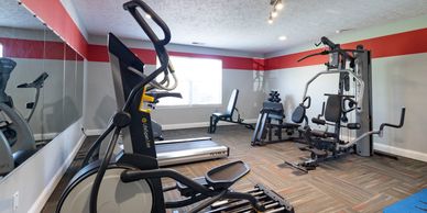 Modern home gym with various exercise machines and equipment.