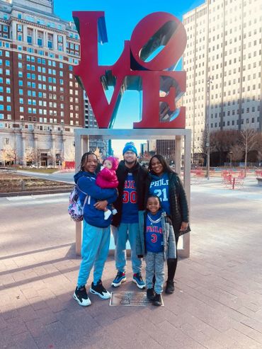 Family posing happily in front of the iconic LOVE sculpture in Philadelphia.