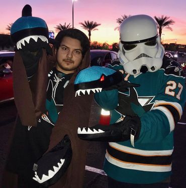 Two people pose with shark Gloves at sunset
