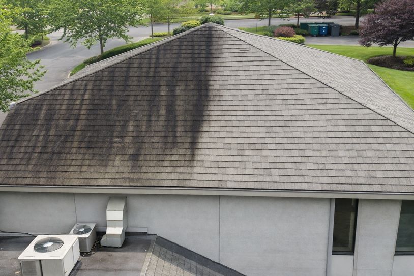 A roof partially covered with black mold or dirt on one side.