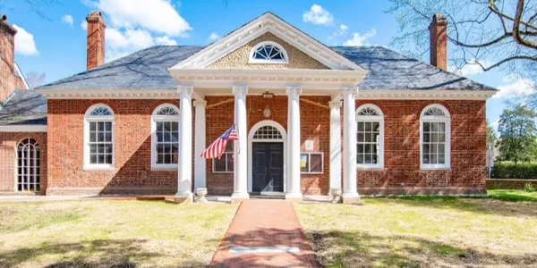 Historic brick building with columns and American flag.
