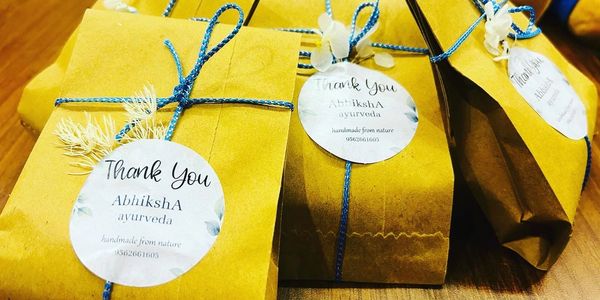 Brown paper packages tied with blue string and thank you tags from AbhikshA Ayurveda.