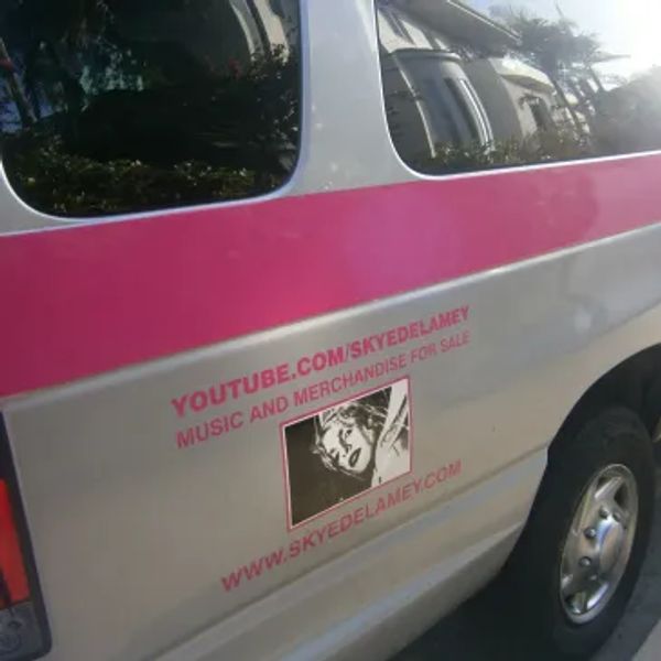 Van with promotional text and image for Skye Delamey music merchandise.