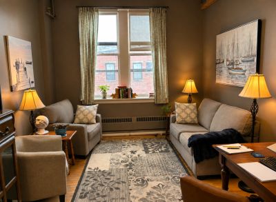 Cozy living room with sofas, lamps, and a patterned rug.