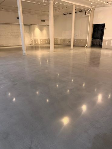 Empty room with polished concrete floor and white pillars.