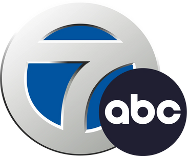 Logo featuring a silver number 7 with a blue background and a black circle containing 'abc'.