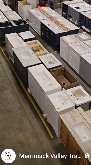 Warehouse filled with bathroom vanities and sinks neatly arranged in rows.
