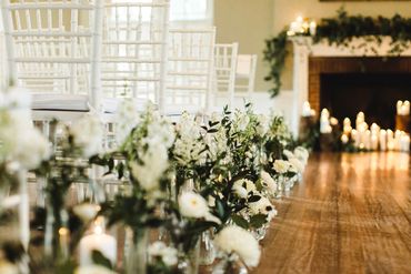White and green flowers lining aisle for wedding