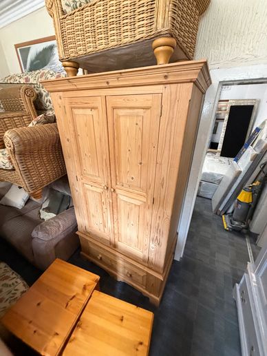 Wooden wardrobe with drawers in a room filled with furniture.