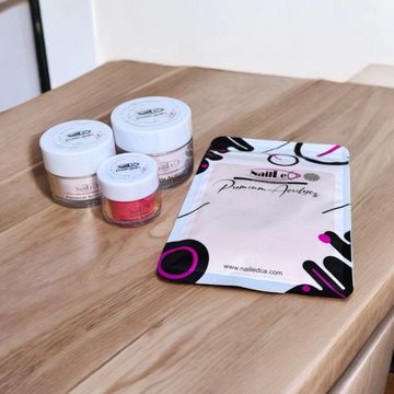Nail care products and a branded pouch on a wooden surface.