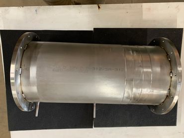 Stainless steel cylindrical pipe with flanges and welded joints.
