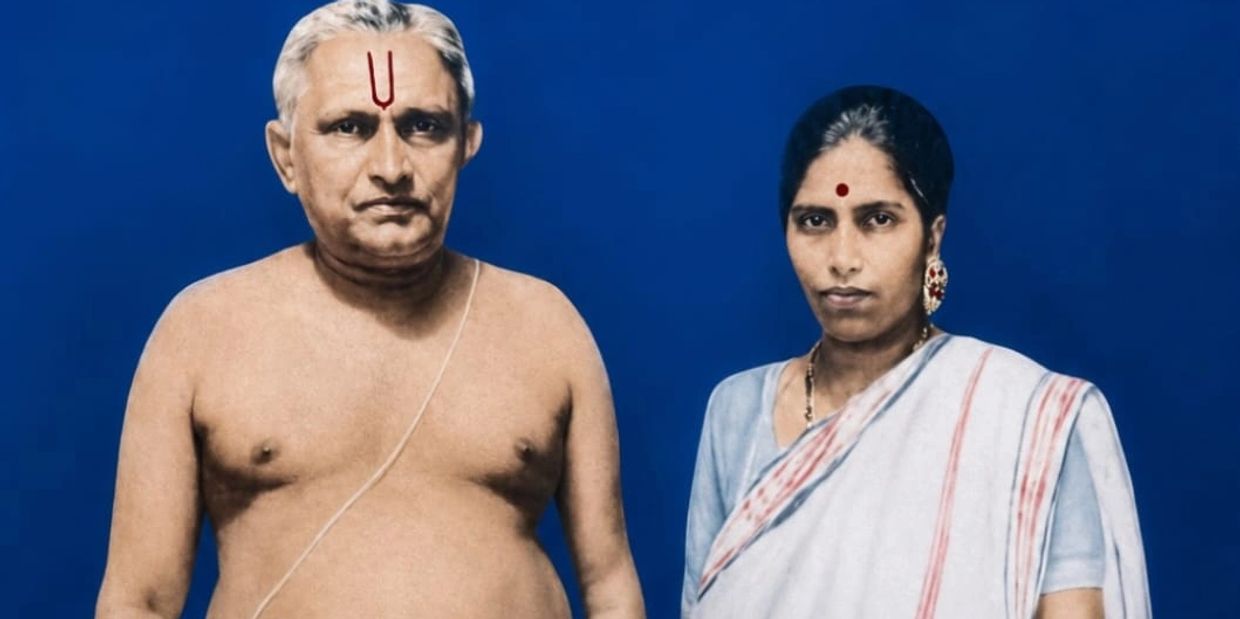 Portrait of an Indian couple against a blue background.