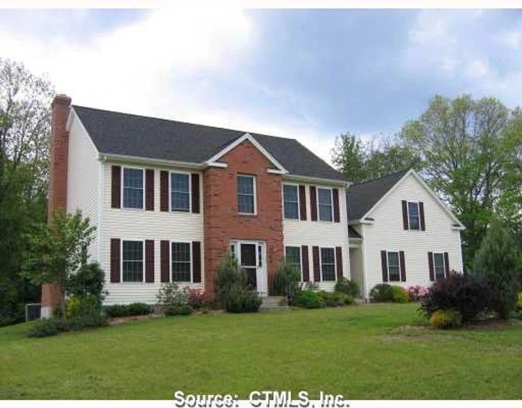 Large two-story suburban house with brick and white siding.