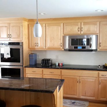 The new kitchen has maple cabinets and a granite counter top and island