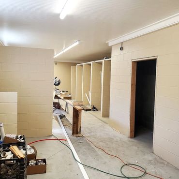 Block shower stalls and bathroom partitions. All masonry is painted for a clean finish and sanitary