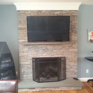 Full bed Tower Hill Ashler stone veneer to ceiling height with a raised bluestone hearth and bluest