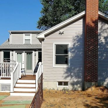 Beautiful new wood stove exterior red brick chimney on the gable of this new 900 square foot house a