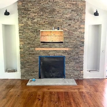 A new Thin Stone veneer around a gas fireplace. The stonework goes directly to the top of the cathed
