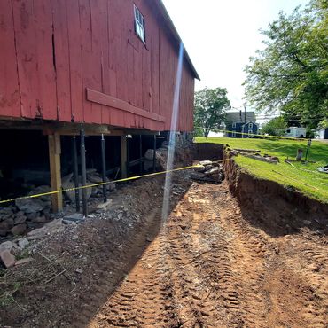 Structure is shored up, exterior grade is excavated and crumbling foundation is removed