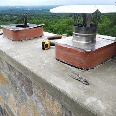 Stainless steel caps cover plates are attached to the masonry flues