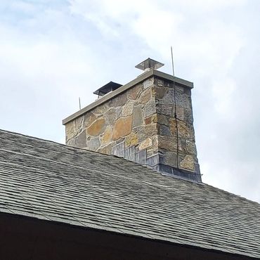 View of the newly rebuilt & restored stone chimney on the roof including complete through lead flas