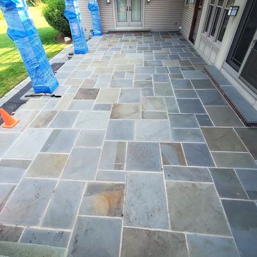 Large bluestone patio in need of rebuild. The elements have caused the bluestone to come apart from