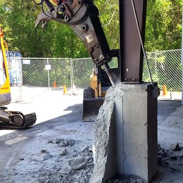 Using heavy equipment for the concrete wall and pier demolition