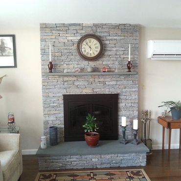 Full bed Blue Ridge Ashler stone veneer to ceiling height with a raised bluestone hearth and bluest
