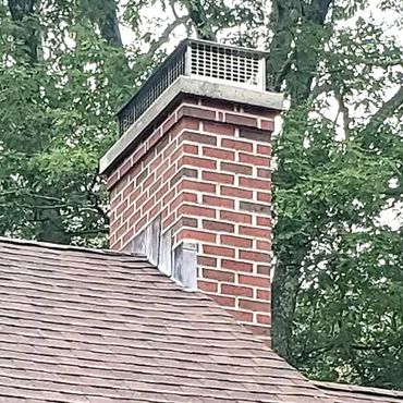 New rebuilt chimney with through lead flashing, a 3" poured concrete cap and a stainless steel cover