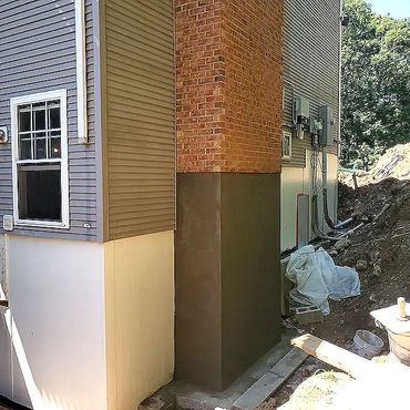 New block foundation plastered with sand and cement rendering, ready for backfilling and completion