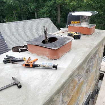 Stainless steel cover plates are glued and installed to the masonry liners after the chimney is rebu