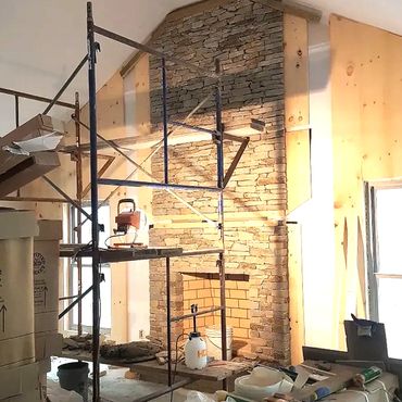 Floor to ceiling stone veneer fireplace