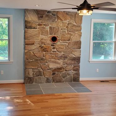 New England Fieldstone wood stove veneer floor to ceiling with a bluestone hearth