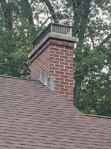 New rebuilt chimney with through lead flashing, a 3" poured concrete cap and a stainless steel cover