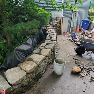 The wall has a radius and a natural incline to match the contour of the property
