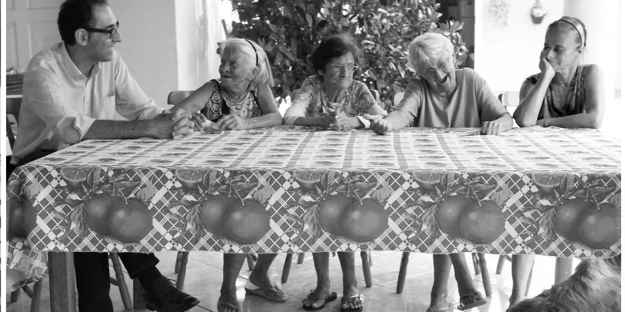 mario moita numa mesa corrida, com 4 velhotas de florianopolis, cantando temas antigos dos açores