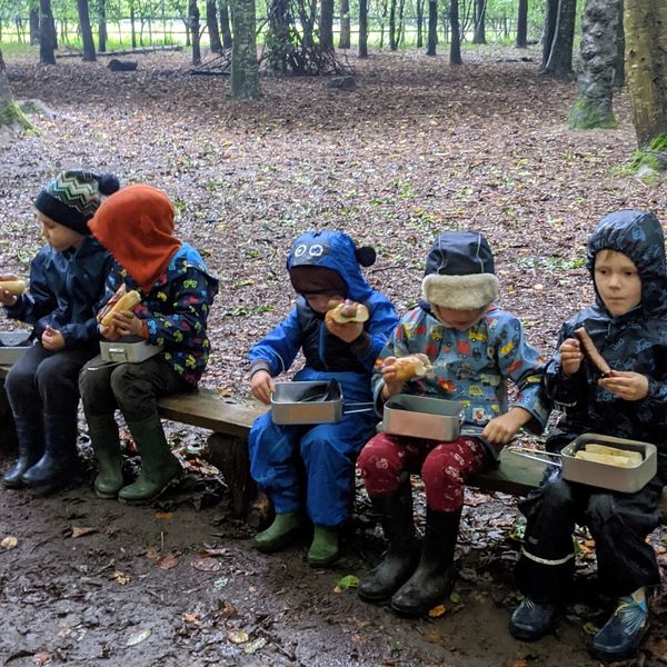 Tiny children in all weather suits eating hotdogs at Fat Squirrel Outdoor