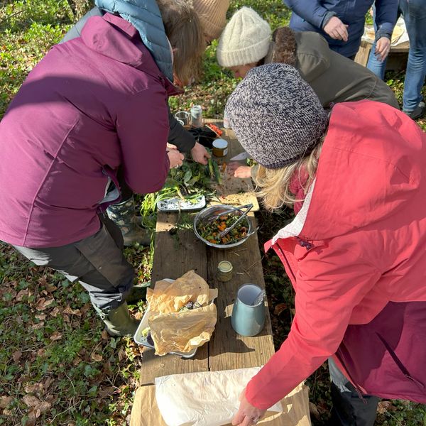 Group of women enjoying a winter cooking experience in a Cotswold woodland