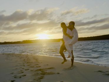Couple embracing on a beach at sunset.