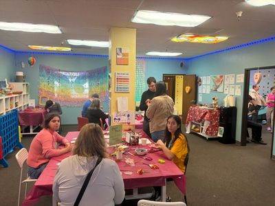 People enjoying crafts and socializing in a colorful community room.