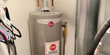 Gray cylindrical water heater installed indoors.