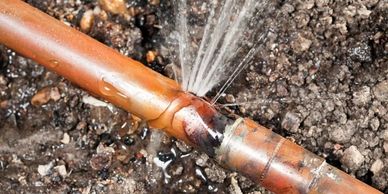 A leaking irrigation pipe spraying water.