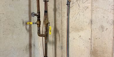 Industrial pipes running along a ceiling with yellow markers.